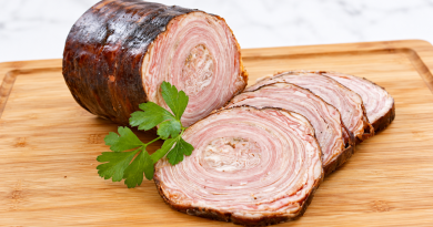Andouille de Guémené traditionnelle coupée en tranches sur une planche en bois, illustrant le patrimoine culinaire breton aujourd'hui menacé.