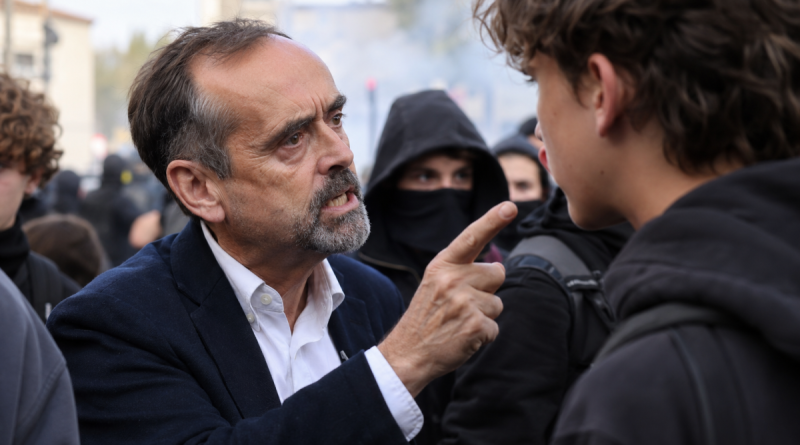 Robert Ménard face à un jeune manifestant lors d’une mobilisation lycéenne à Béziers, dans une scène tendue au milieu d’un rassemblement.